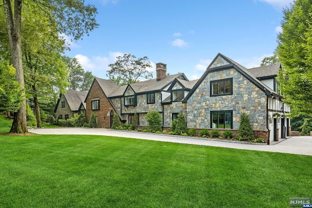 tudor house featuring a front lawn and a garage