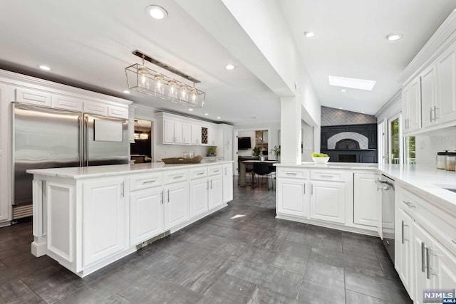 kitchen with kitchen peninsula, pendant lighting, white cabinets, and stainless steel appliances