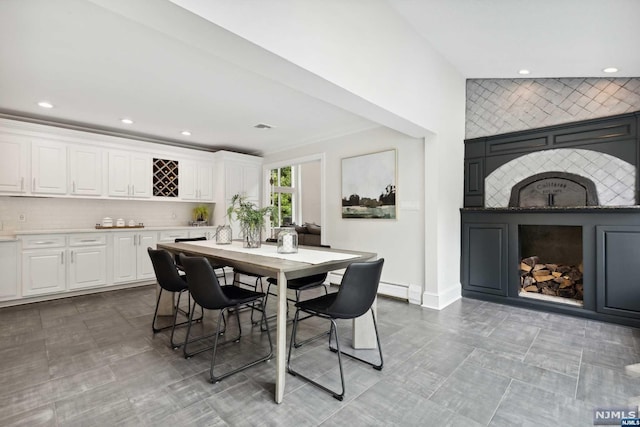 dining area with a tile fireplace and a baseboard radiator