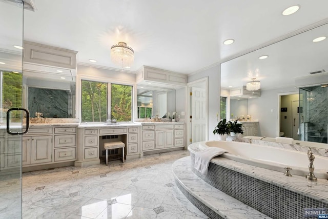 bathroom with vanity, a relaxing tiled tub, and crown molding