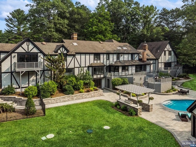 rear view of property featuring a fenced in pool, a sunroom, a yard, and a patio