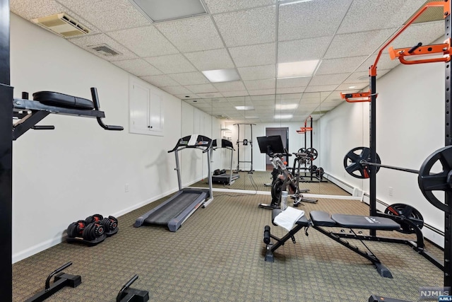 exercise room featuring carpet flooring and a paneled ceiling