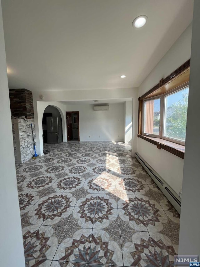 unfurnished living room featuring a wall mounted air conditioner and a baseboard heating unit