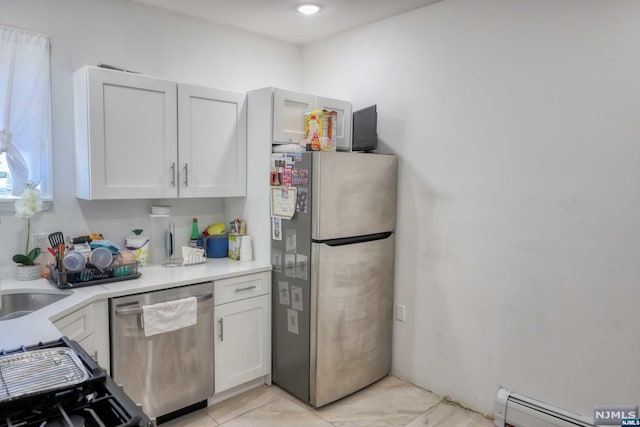 kitchen featuring stainless steel appliances, white cabinetry, a baseboard heating unit, and sink