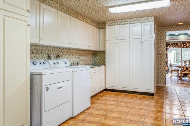 clothes washing area with cabinets, separate washer and dryer, and sink