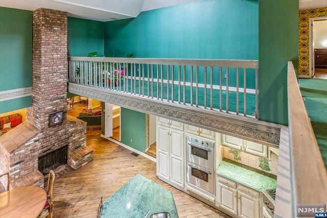 interior space with light hardwood / wood-style floors and a brick fireplace