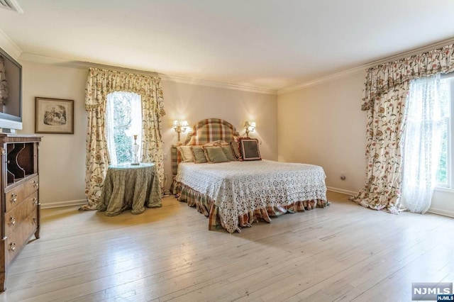 bedroom with light hardwood / wood-style floors and crown molding