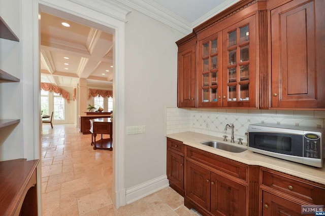 kitchen featuring coffered ceiling, crown molding, sink, decorative backsplash, and beamed ceiling