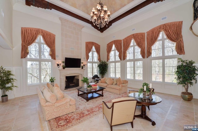 living room featuring a towering ceiling, a wealth of natural light, and ornamental molding