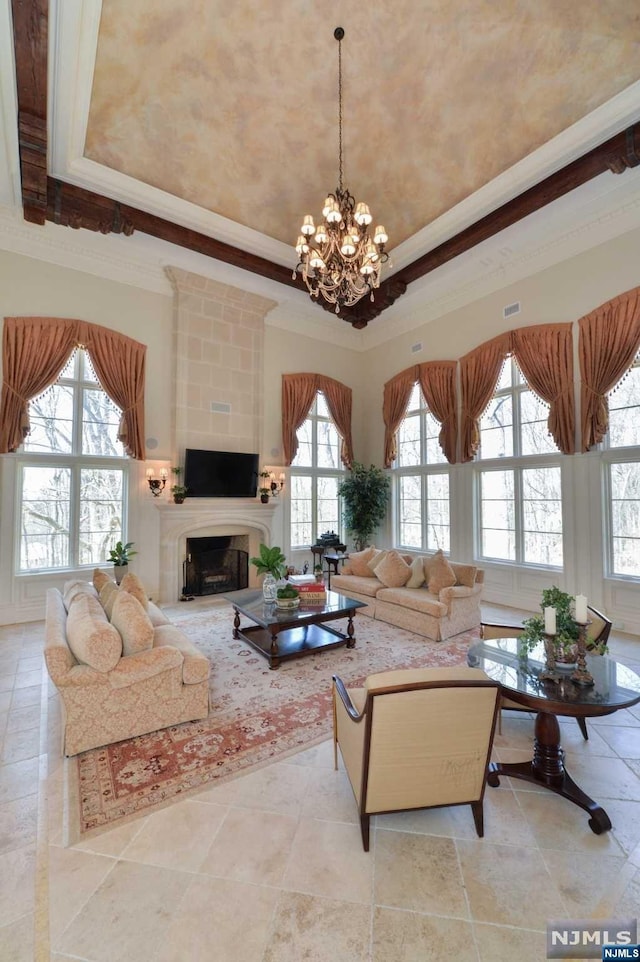 living room featuring a large fireplace, a healthy amount of sunlight, and ornamental molding