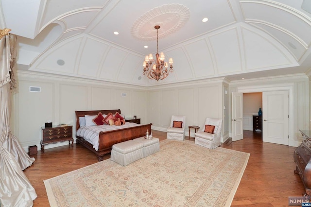 bedroom featuring a chandelier, hardwood / wood-style floors, and crown molding