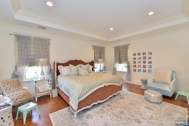 bedroom with a raised ceiling, crown molding, and dark hardwood / wood-style floors