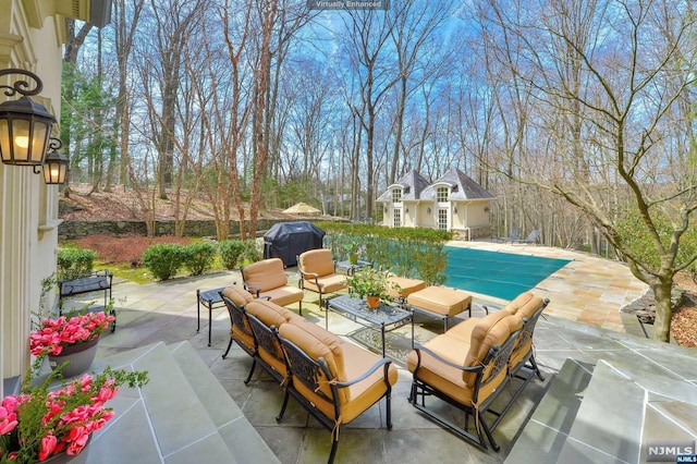 view of patio / terrace with an outdoor hangout area, grilling area, and a covered pool