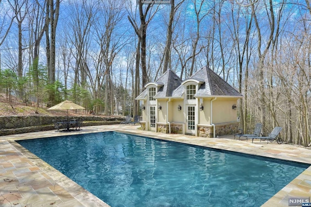 view of swimming pool with a patio and an outdoor structure