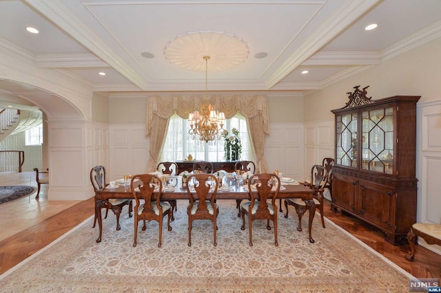 dining space with a wealth of natural light, crown molding, parquet floors, and an inviting chandelier