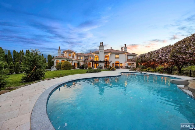 pool at dusk with a lawn