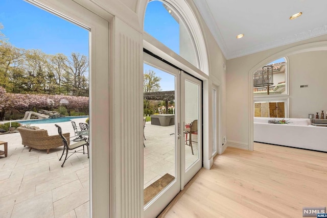 doorway to outside with french doors, light hardwood / wood-style floors, and ornamental molding