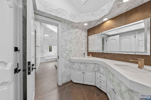 bathroom with vanity, tile walls, and a washtub