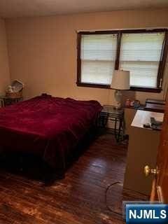 bedroom with dark wood-type flooring