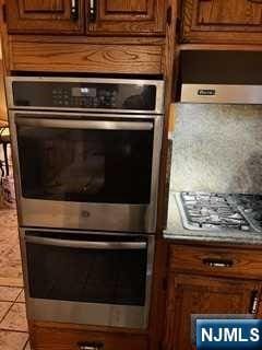 kitchen with light tile patterned floors and stainless steel appliances