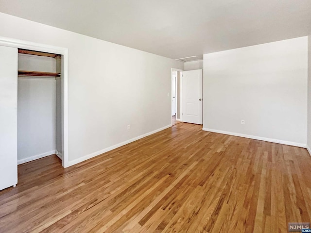 unfurnished bedroom with hardwood / wood-style floors and a closet