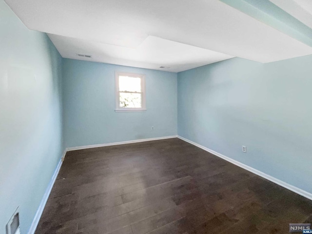 empty room featuring dark hardwood / wood-style flooring