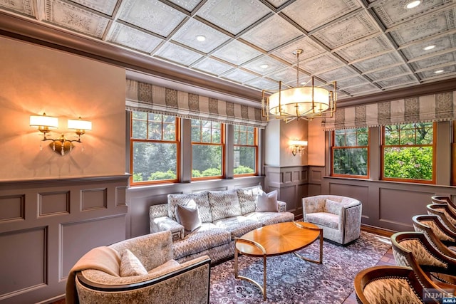 living room with crown molding and an inviting chandelier