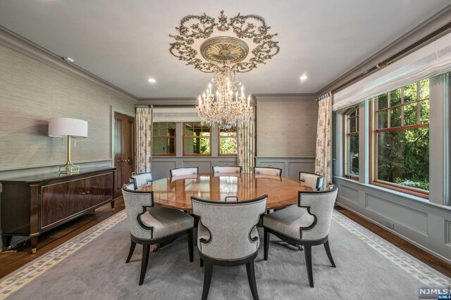 dining area with wood-type flooring, a wealth of natural light, and ornamental molding