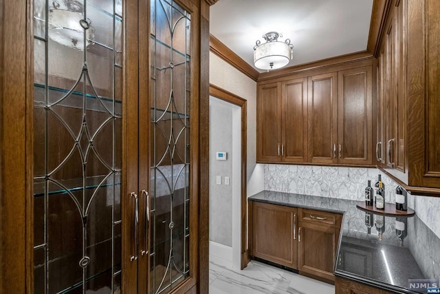 kitchen featuring backsplash, dark stone counters, and ornamental molding