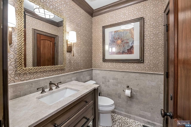 bathroom with vanity, toilet, crown molding, and tile walls