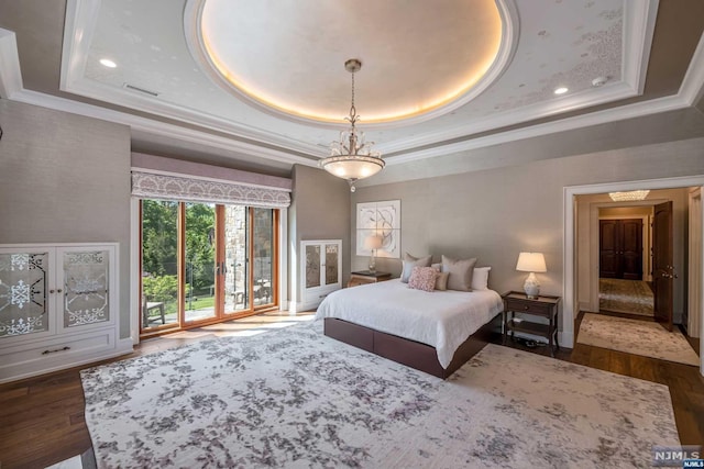 bedroom with a raised ceiling, ornamental molding, dark hardwood / wood-style floors, and access to outside