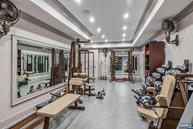 workout area with ornamental molding and a tray ceiling