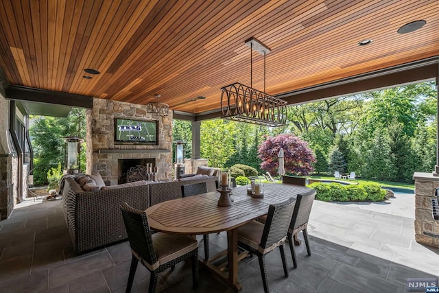 view of patio with an outdoor living space with a fireplace