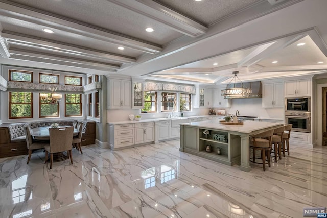 kitchen featuring hanging light fixtures, a kitchen island, a wealth of natural light, and crown molding