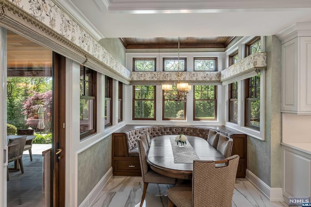 sunroom featuring a chandelier, breakfast area, and a healthy amount of sunlight