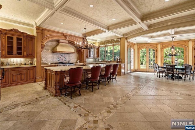 bar featuring pendant lighting, tasteful backsplash, plenty of natural light, and coffered ceiling