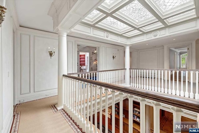 hall featuring ornate columns, ornamental molding, and coffered ceiling