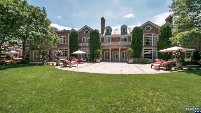 back of property with a yard, a patio, and french doors