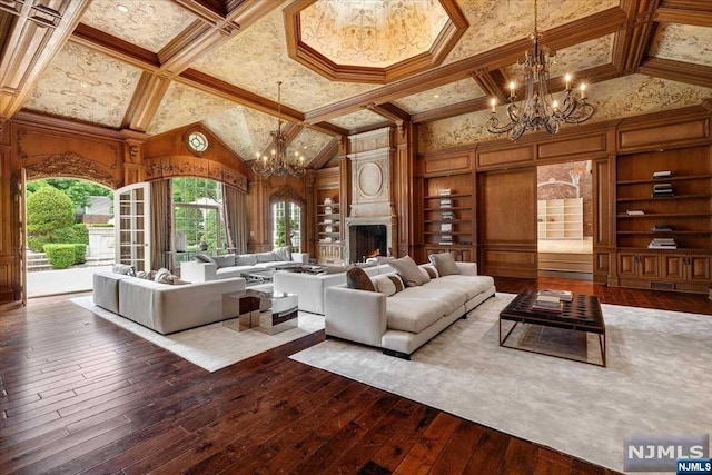 living room featuring a high end fireplace, wood-type flooring, high vaulted ceiling, and built in features