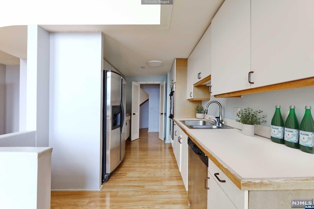 kitchen featuring white cabinetry, sink, stainless steel appliances, and light hardwood / wood-style flooring