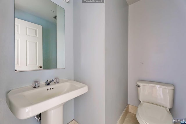 bathroom with tile patterned flooring, toilet, and sink