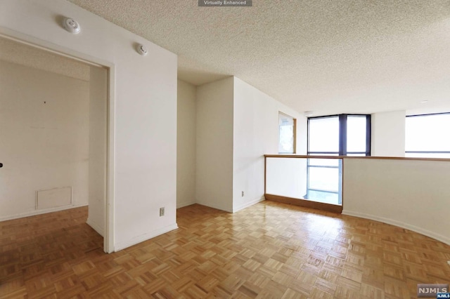 unfurnished room featuring a textured ceiling and light parquet flooring