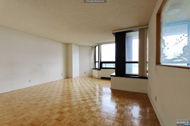 empty room with a textured ceiling and light parquet floors