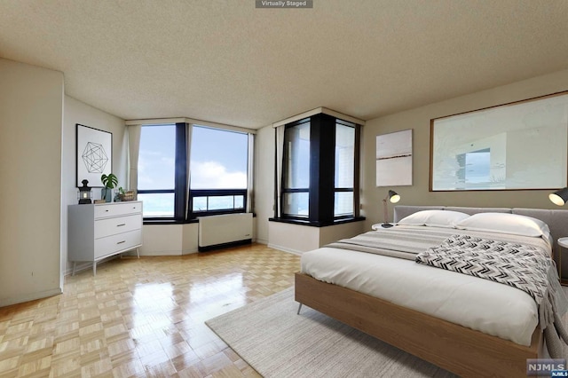 bedroom with light parquet flooring and a textured ceiling