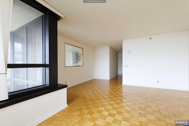 spare room with light parquet floors and a textured ceiling