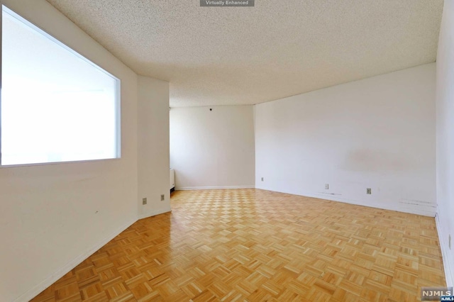 unfurnished room with a textured ceiling and light parquet floors