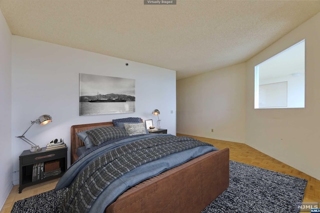 bedroom with parquet floors and a textured ceiling