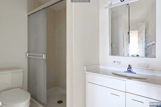 bathroom featuring vanity, toilet, and an enclosed shower