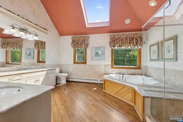 bathroom featuring hardwood / wood-style floors, vanity, a skylight, and a baseboard heating unit