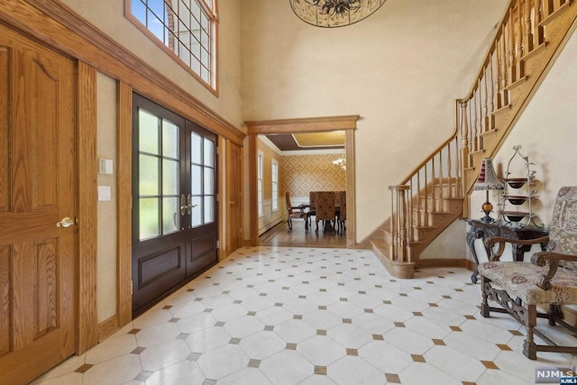 entryway featuring french doors and a towering ceiling